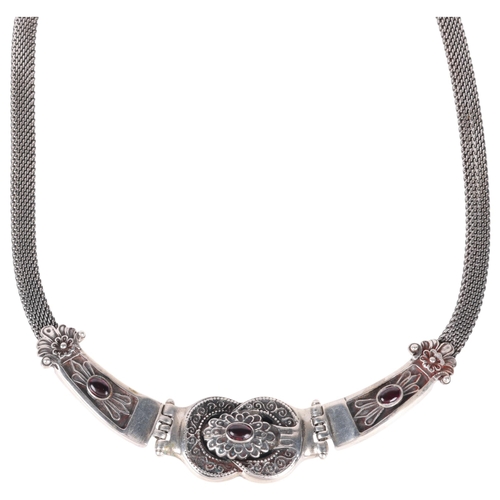 1364 - A Mexican sterling silver garnet collar necklace, relief embossed decoration, maker H64, 44cm, 55.7g