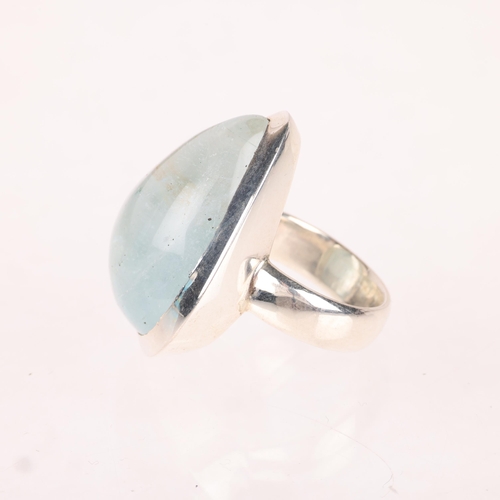 1379 - A heavy sterling silver aquamarine dress ring, set with pear cabochon aquamarine, setting height 30.... 