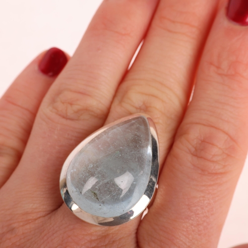 1379 - A heavy sterling silver aquamarine dress ring, set with pear cabochon aquamarine, setting height 30.... 