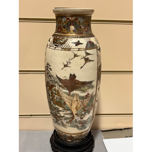 219 - A pair of Japanese Satsuma porcelain vases, with painted and gilded warriors, on carved wood stands,... 