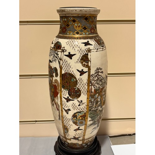 219 - A pair of Japanese Satsuma porcelain vases, with painted and gilded warriors, on carved wood stands,... 