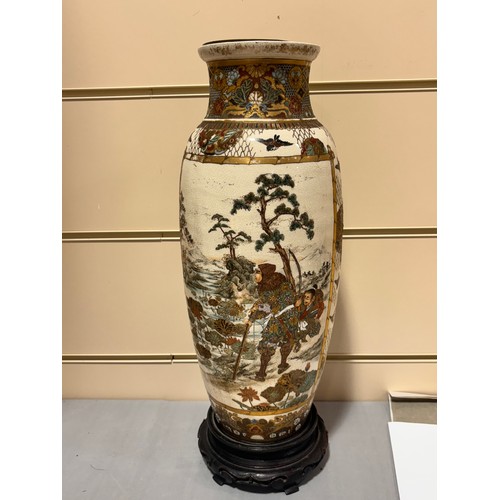 219 - A pair of Japanese Satsuma porcelain vases, with painted and gilded warriors, on carved wood stands,... 