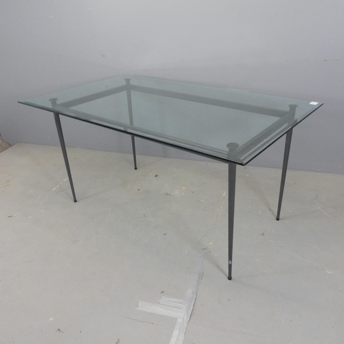 2589 - A contemporary rectangular glass top dining table, with bevelled edges and raised on tapered metal l... 