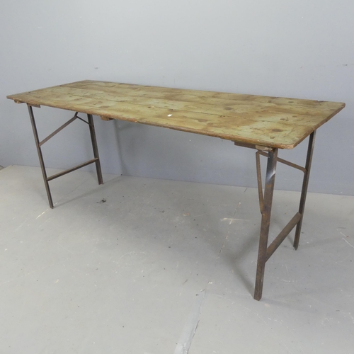 2630 - A vintage pine plank-top trestle table with folding metal legs. W177cm, H77cm, D60cm.