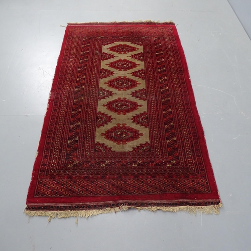 2302 - A Persian wool red ground rug with five central lozenges, 156cm x 92cm.