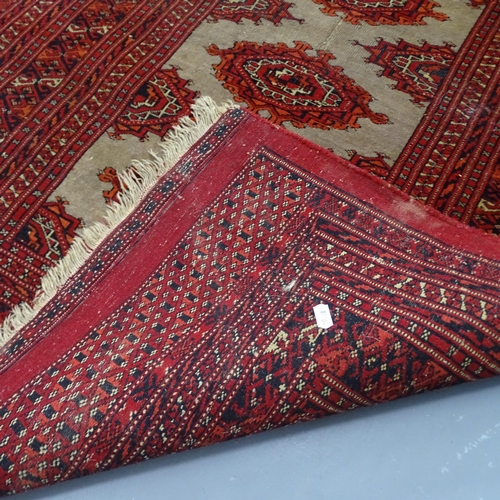 2302 - A Persian wool red ground rug with five central lozenges, 156cm x 92cm.