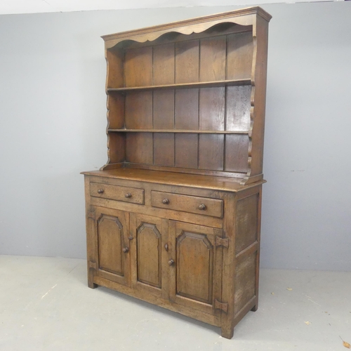 2520 - An early 20th century oak two-section dresser, with open plate rack, two drawers and cupboards under... 