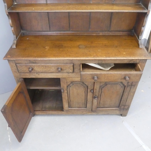 2520 - An early 20th century oak two-section dresser, with open plate rack, two drawers and cupboards under... 