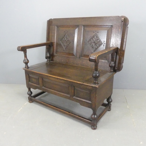 2538 - An early 20th century panelled oak monk's bench, with lifting seat and baluster turned supports. Ove... 