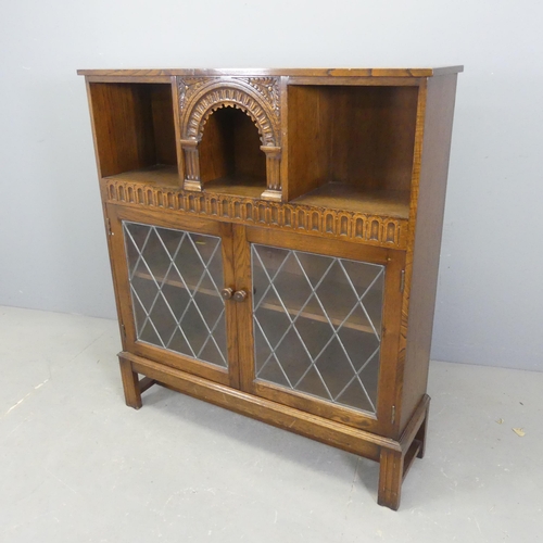 2543 - An early 20th century oak bookcase, with two lattice glazed doors and carved decoration. Width 101cm... 