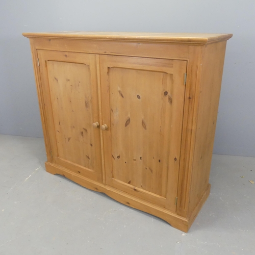 2554 - A modern pine hall cabinet, with two panelled doors and shelf fitted interior. W126cm, H109cm, D44cm... 