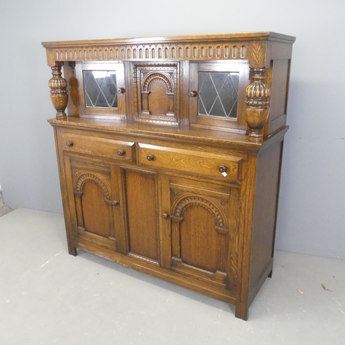 2559 - A 1960s oak two-section court cupboard, by Lock of London, with carved and panelled decoration. Widt... 