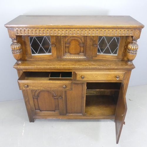 2559 - A 1960s oak two-section court cupboard, by Lock of London, with carved and panelled decoration. Widt... 