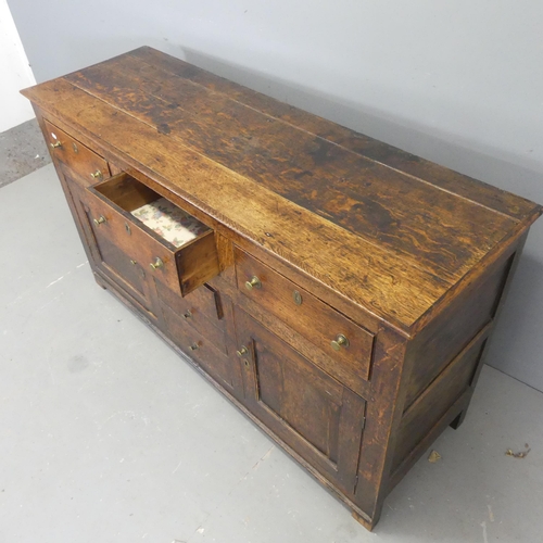 2570 - A 19th century oak sideboard, with six drawers, two panelled cupboard doors, and raised on stile leg... 