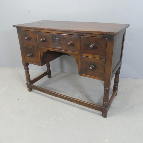 2575 - A reproduction oak kneehole sideboard / writing table, with five drawers and turned legs. Width 99cm... 