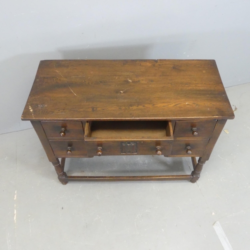 2575 - A reproduction oak kneehole sideboard / writing table, with five drawers and turned legs. Width 99cm... 