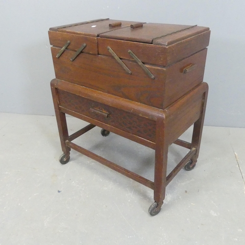 2580 - A 1930s oak cantilever sewing box. Width 49cm, height 57cm, depth 31cm.