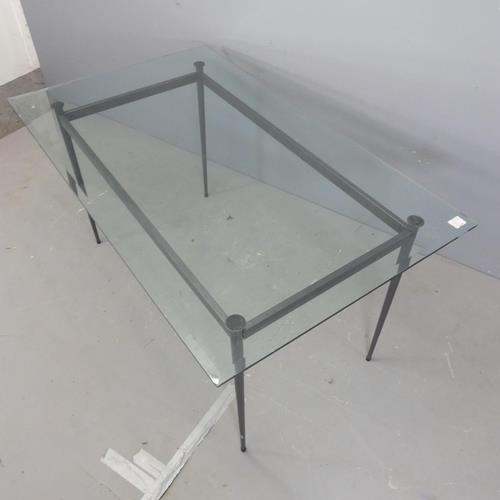 2589 - A contemporary rectangular glass top dining table, with bevelled edges and raised on tapered metal l... 