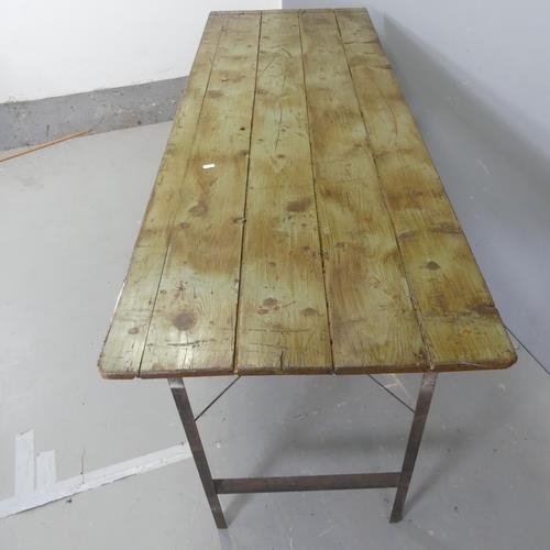 2630 - A vintage pine plank-top trestle table with folding metal legs. W177cm, H77cm, D60cm.