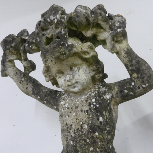 2635 - A weathered concrete garden statue, study of a cherub holding a garland. Height 93cm.