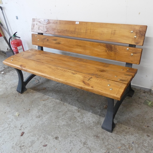 2644 - A pine garden bench on cast iron frame. Length 138cm, height 77cm, depth 60cm.