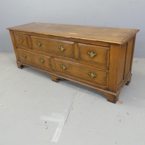 2671 - A Georgian style oak low chest of five drawers, with brass pulls and raised on bracket feet. Width 1... 