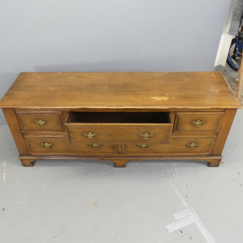 2671 - A Georgian style oak low chest of five drawers, with brass pulls and raised on bracket feet. Width 1... 