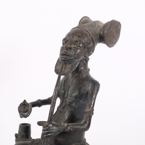 123 - A patinated bronze figure, Yiruba, Nigeria, study of a seated man smoking a pipe, H29cm