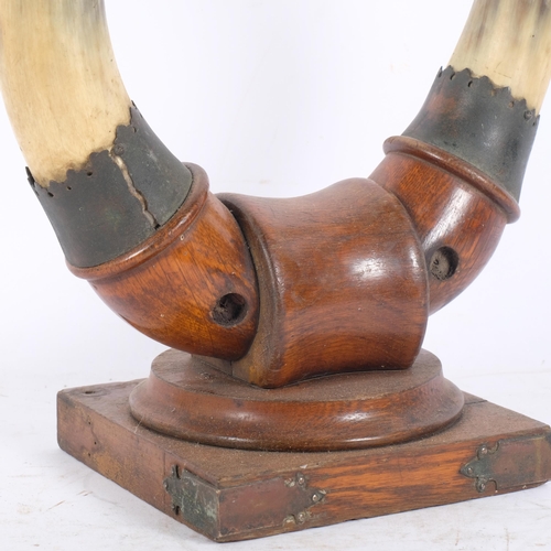 152 - TAXIDERMY - an early 20th century cow horn dinner gong on oak stand (missing gong), H36cm