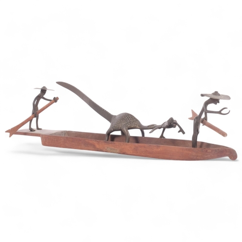 194 - A Nigerian bronze fishing group, depicting figures paddling while being attached by a crocodile, cir... 