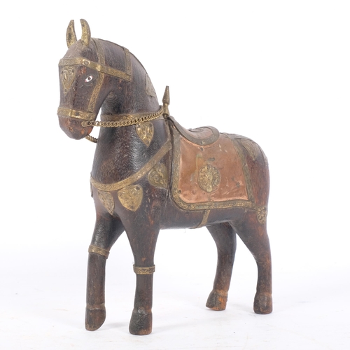 231 - A Middle Eastern carved hardwood ceremonial horse with brass and copper adornments, H20cm