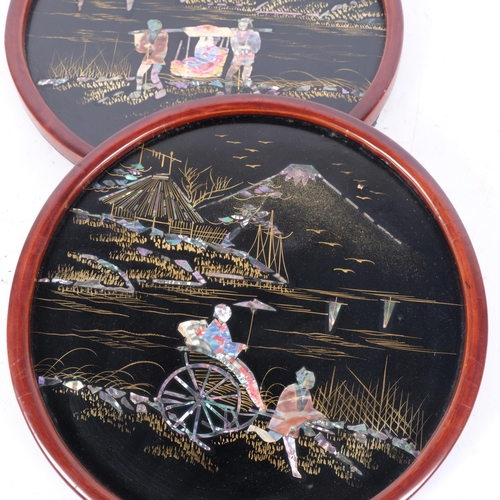 253 - A pair of Japanese black lacquered circular panels, decorated with Mount Fuji scenes with gilded and... 