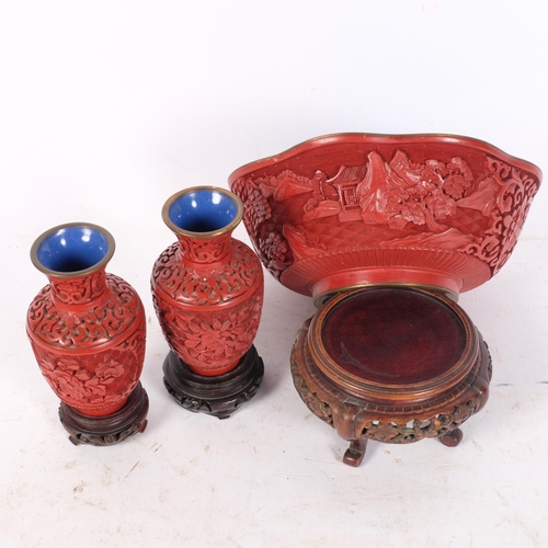 266 - A Chinese cinnabar bowl with blue enamelled interior, diameter 18cm, and a pair of small cinnabar va... 