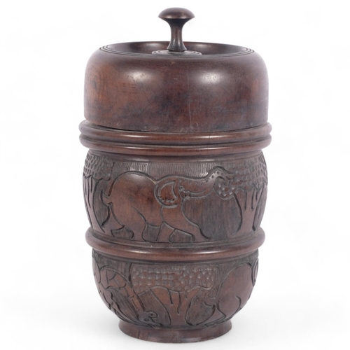 85 - An African turned hardwood cylindrical box and cover, with engraved animal decoration, H31cm