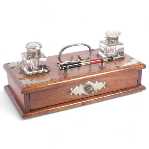 91 - An early 20th century oak desk stand, 2 fitted glass inkwells, with drawer under and plated mounts, ... 