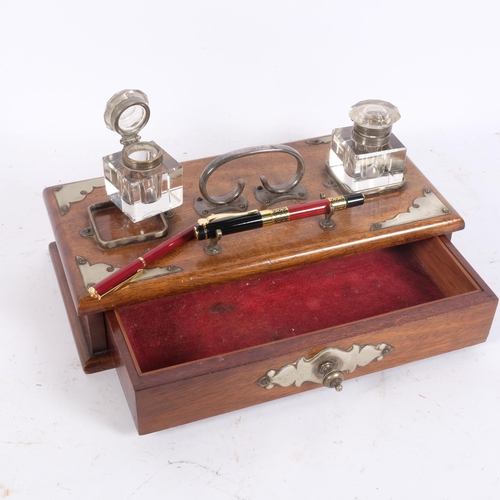 91 - An early 20th century oak desk stand, 2 fitted glass inkwells, with drawer under and plated mounts, ... 