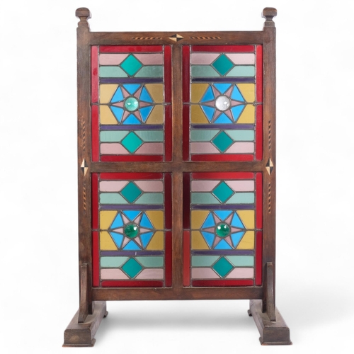 99 - LIBERTY & COMPANY LTD - an early 20th century oak framed fire screen with 4 coloured leadlight glass... 