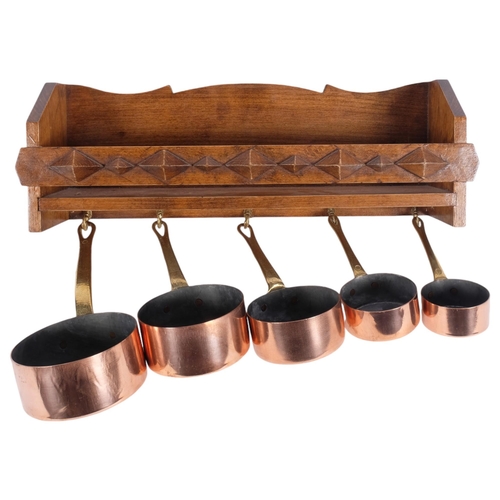 440 - A graduated set of 5 copper and brass saucepans, on wall-hanging rack, W41cm