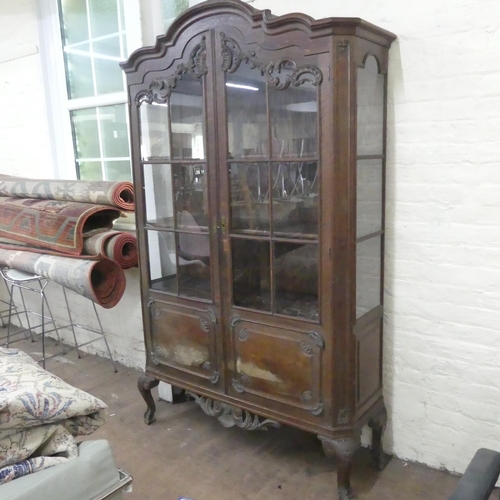 2321 - A French oak arch top display cabinet, with two lattice glazed doors, carved decoration and raised o... 