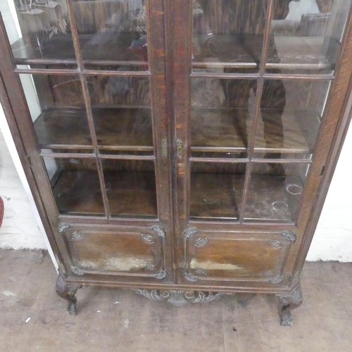 2321 - A French oak arch top display cabinet, with two lattice glazed doors, carved decoration and raised o... 