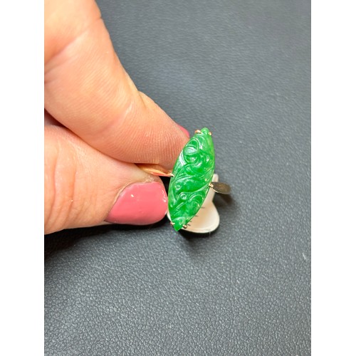 1144 - A Chinese 18ct gold jade panel ring, maker WH, set with carved marquise cabochon jade depicting bird... 