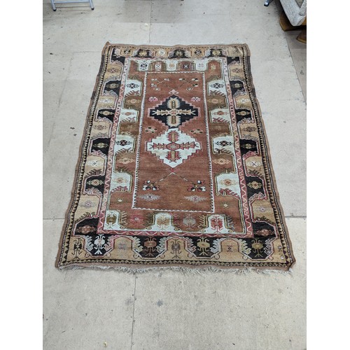 2326 - An antique cream and brown ground Turksh Milas rug, 186x132cm.