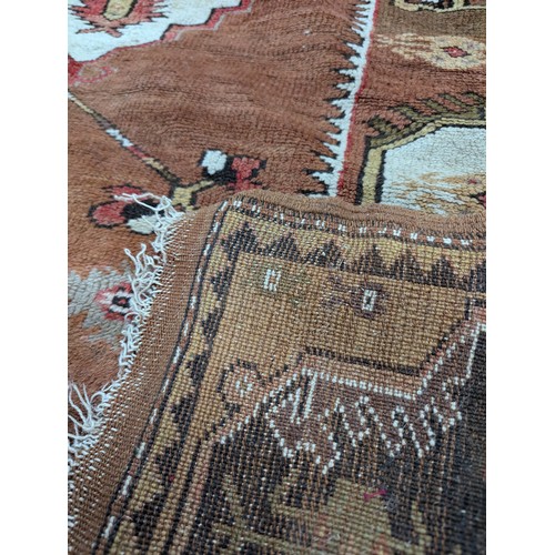 2326 - An antique cream and brown ground Turksh Milas rug, 186x132cm.