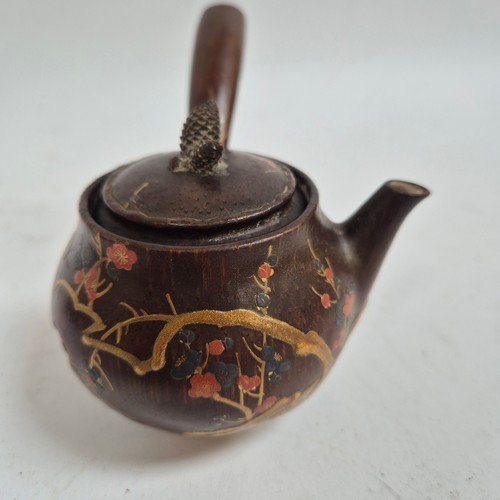 252 - A Japanese coconut tea kettle, with painted and gilded decoration, H8cm, together with a carved hard... 