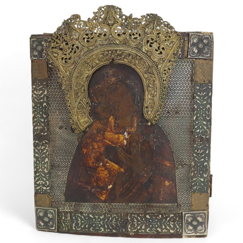 19 - An Antique Russian icon depicting the Mother of God, oil on wood panel with relief pierced silver ha... 