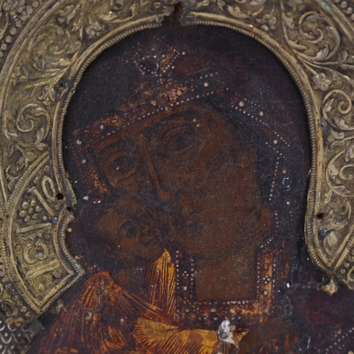 19 - An Antique Russian icon depicting the Mother of God, oil on wood panel with relief pierced silver ha... 