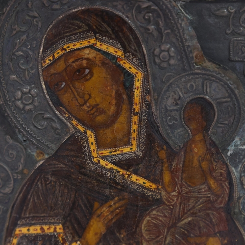 20 - An Antique Russian icon depicting the Mother of God, oil on wood panel with relief pierced silver ha... 