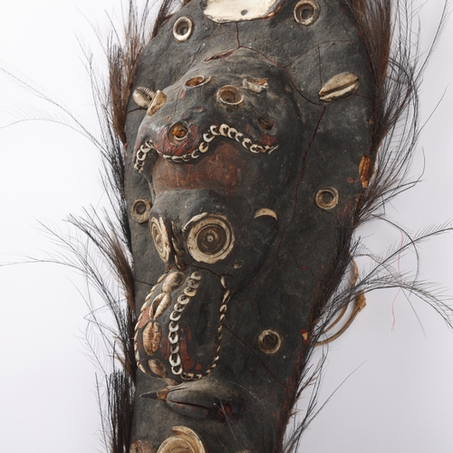 47 - Papua New Guinea wooden Tribal shield, with inset shells and feather surround, length 75cm