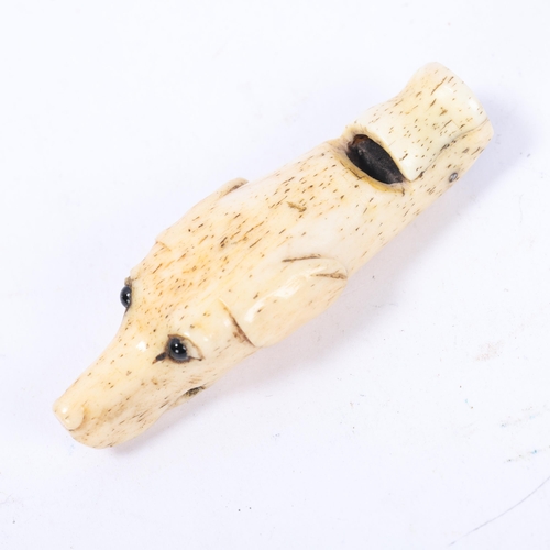 69 - A 19th century carved bone dog's head design whistle with glass eyes, length 68mm