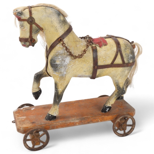 157 - Antique pull-along carved wood toy horse on wheeled base, base length 36cm